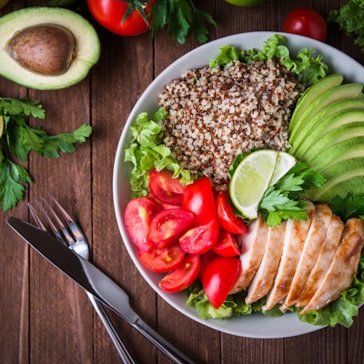 a healthy dish made up of avocado, salmon, whole grains, tomato and salad