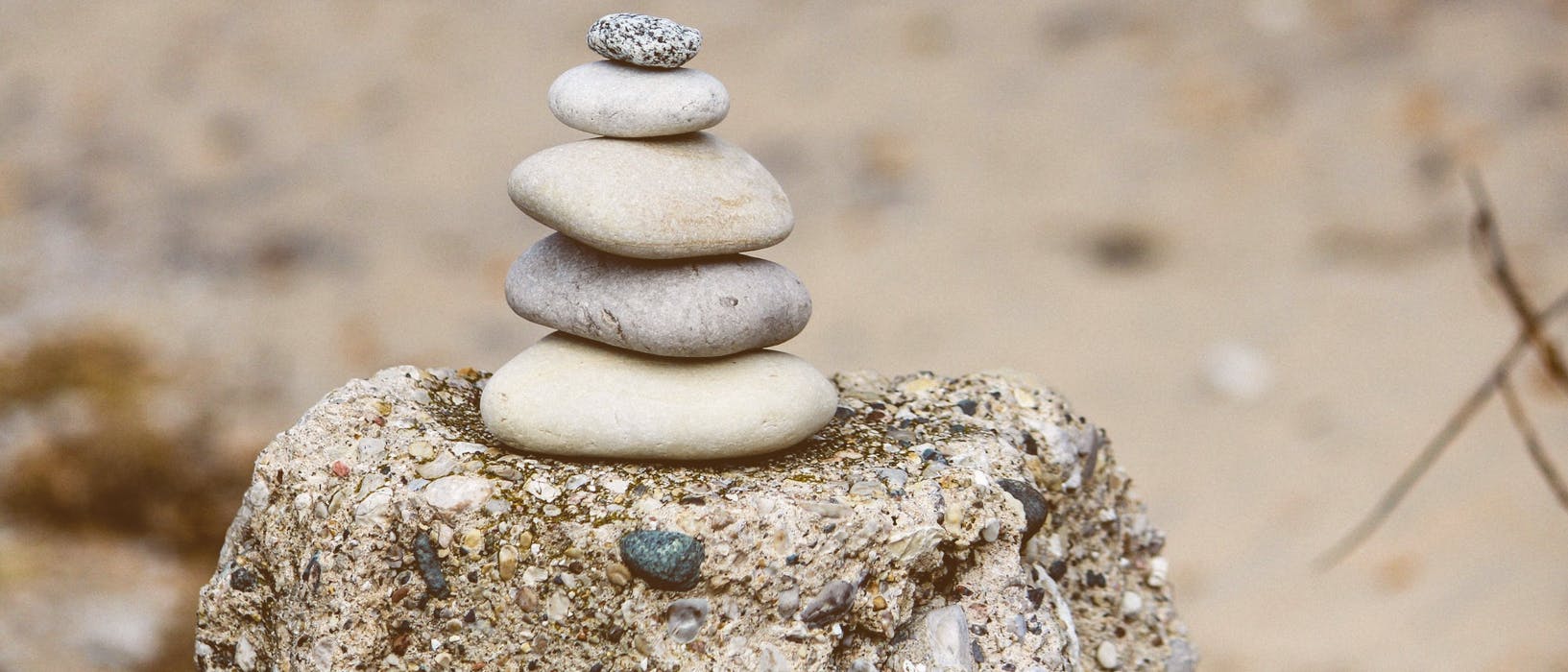 Rocks stacked on a post at the beach