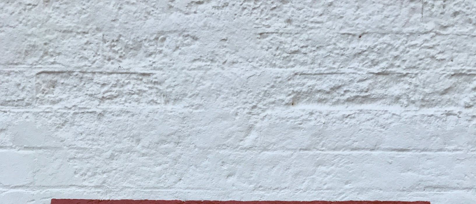 A red stop sign painted on a white wall