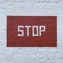A red stop sign painted on a white wall