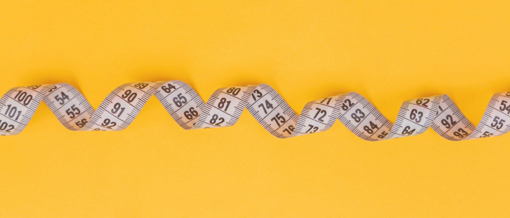 silver and black necklace on yellow textile