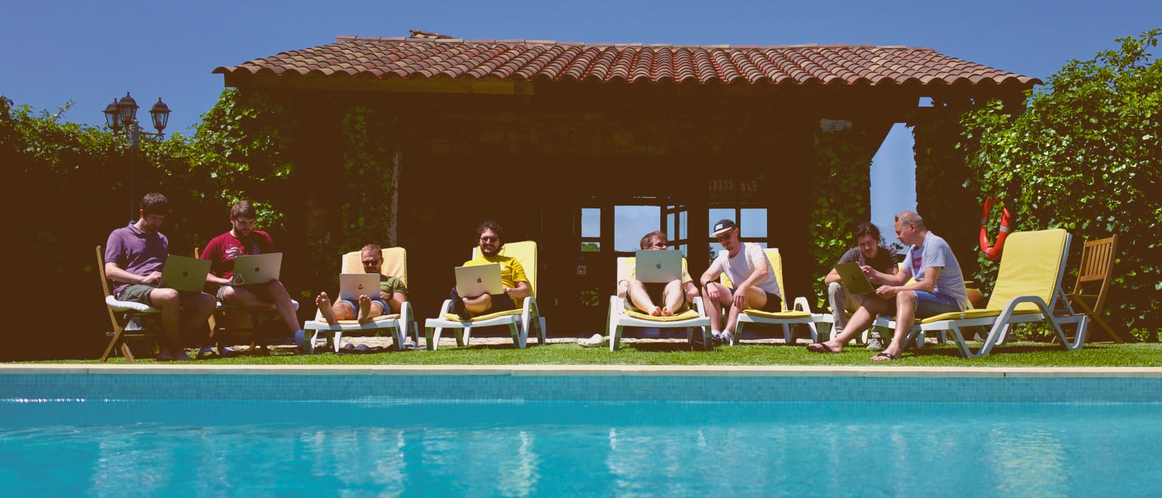 The Pocketworks team working by the pool in Lisbon