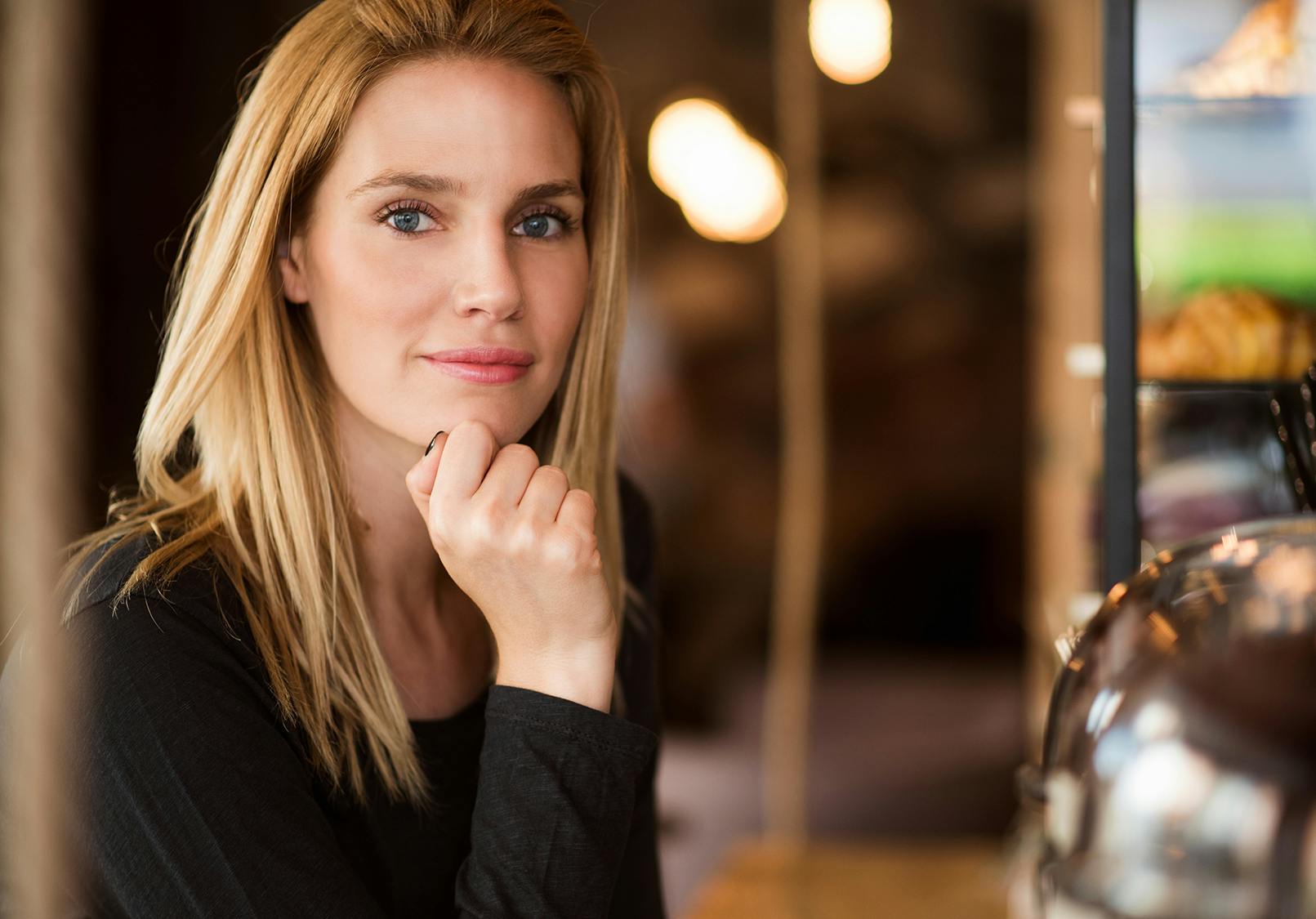 Pensive blonde woman with a coy smile.