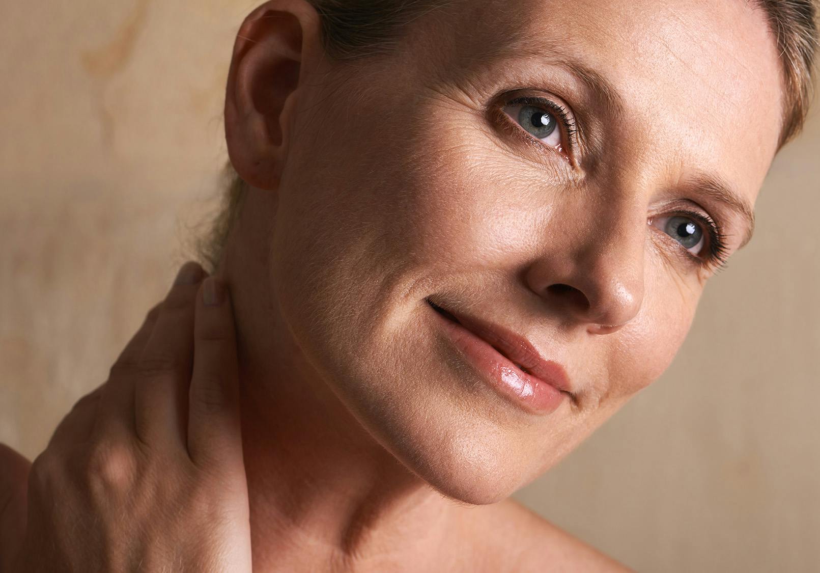 Older woman caressing her elegant neck.