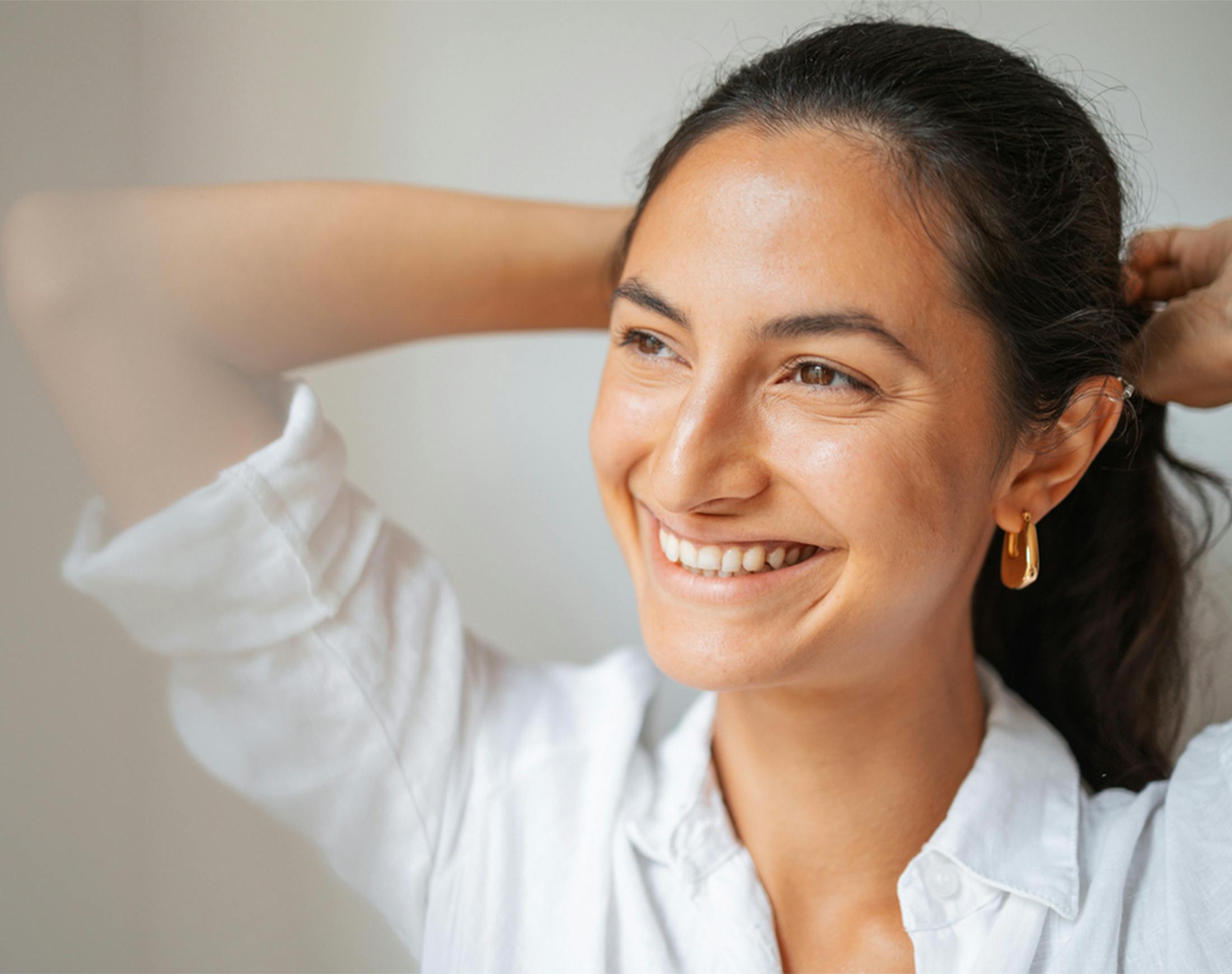 smiling woman tying her hair back
