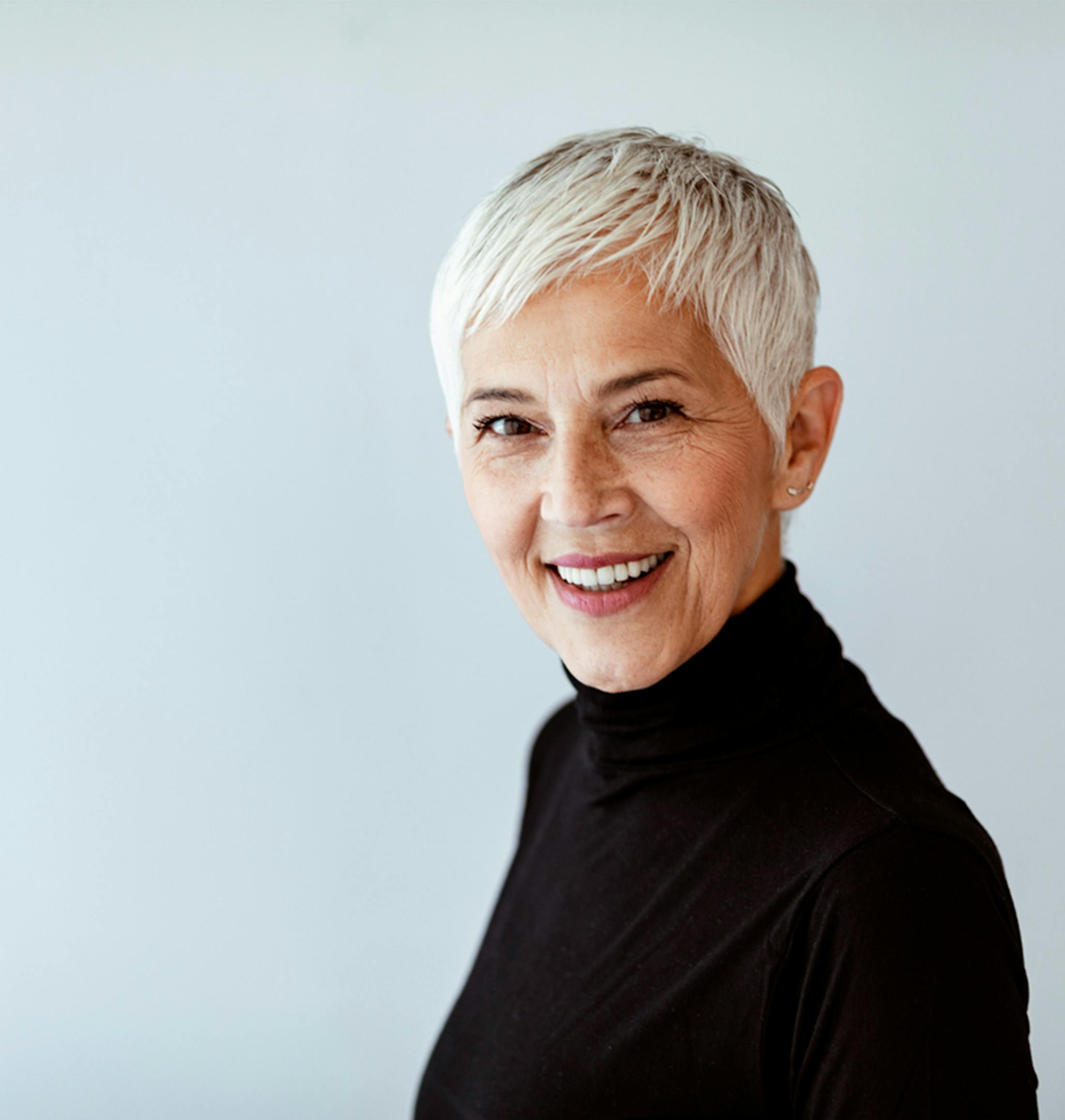 older woman smiling over her shoulder