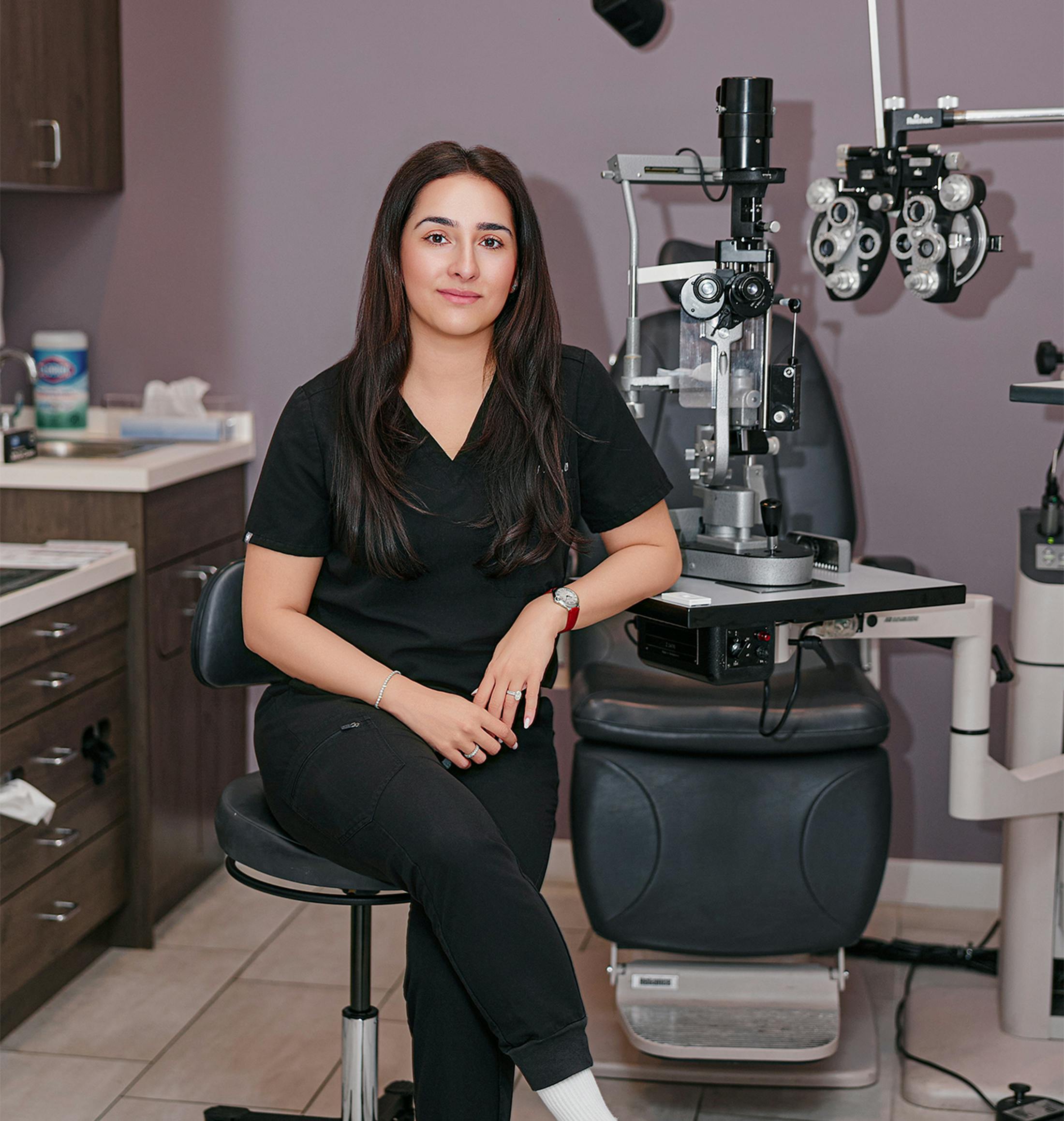 doctor sitting by an eye exam machine