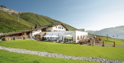 Restaurant Chadafö Marguns mit Sonnenterrasse | Sommer Das Bergrestaurant Chadafö Marguns mit Sonnenterrasse auf Marguns zeigt sich als modernes, helles Bergrestaurant mit markanter weißser Fassade und Rundbogen-Architektur
