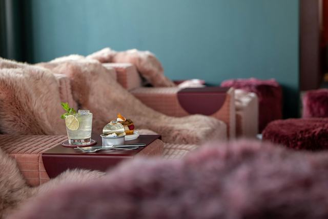Pinker Innenraum des White Marmot auf Corviglia mit einem  Tisch mit zwei Cocktails auf der linken Seite im Bild..