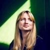 Linnea looking into the distance in a sunlit green room.