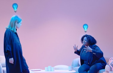 Two women talking with spooky blue lightbulbs floating above their heads.