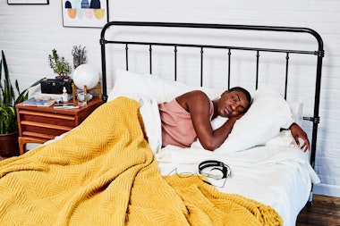 woman lying in bed with her eyes shut looking peaceful