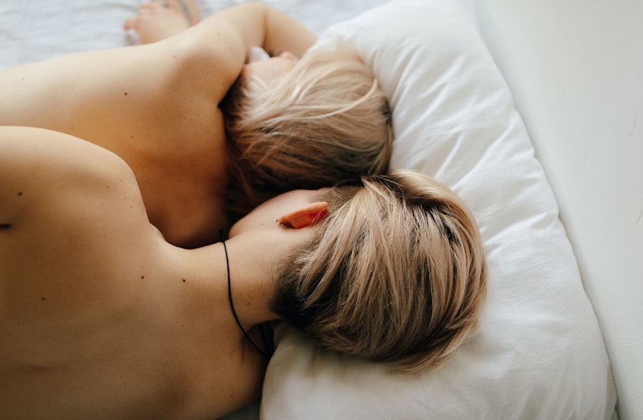 Couple lying in bed, facing away