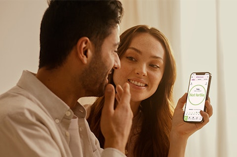 Woman showing her Natural Cycles app to her partner.