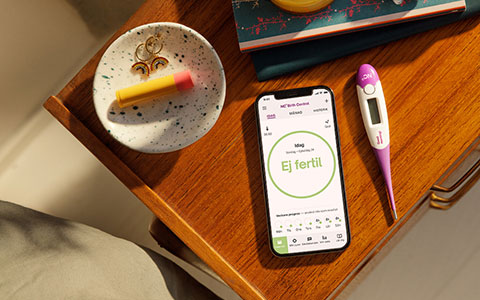 nature cycle -appen och BBT-termometern lägger på en nattduksbord redo för användaren att börja sin morgonrutin。