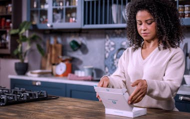 Woman in kitchen opening letsgetchecked test kit