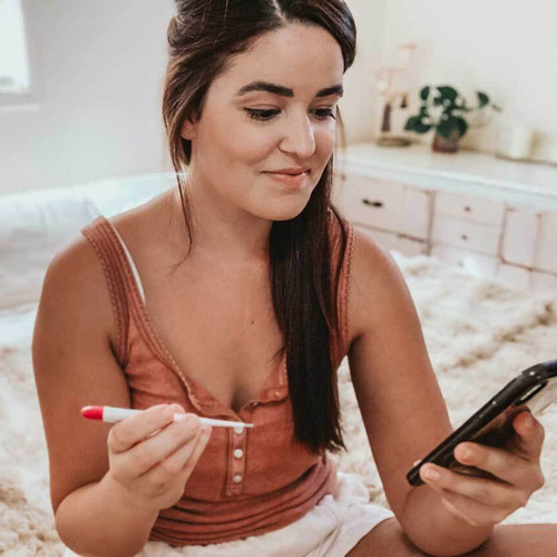 Abby holding a phone and a thermometer
