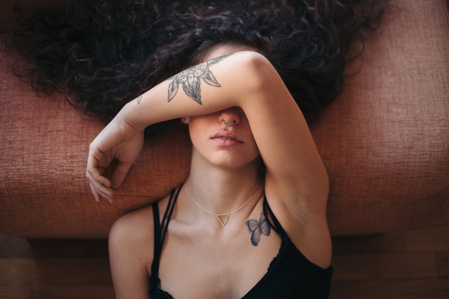 Woman leaning back with her arm over her face