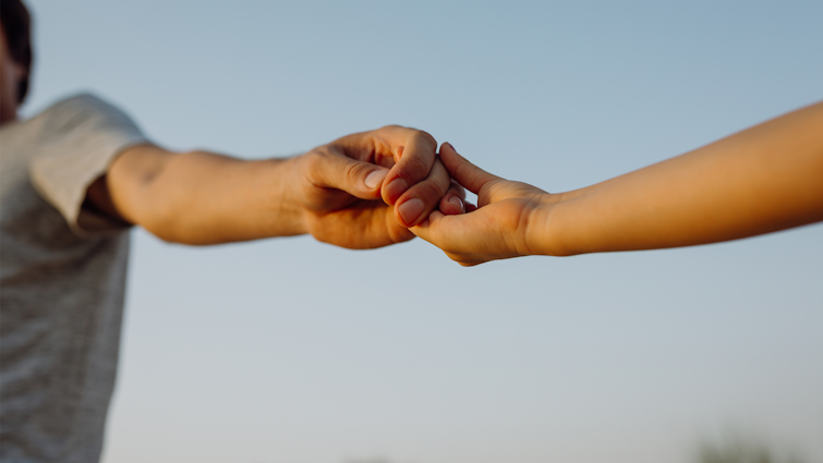 Close up of couple holding hands outside