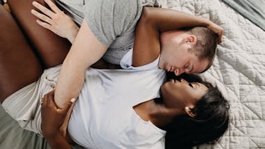 Couple cuddling on bed