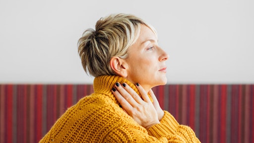 Profile view of woman with short hair wearing a yellow jumper