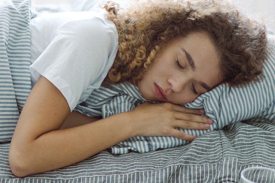 Woman lying in bed with her eyes closed