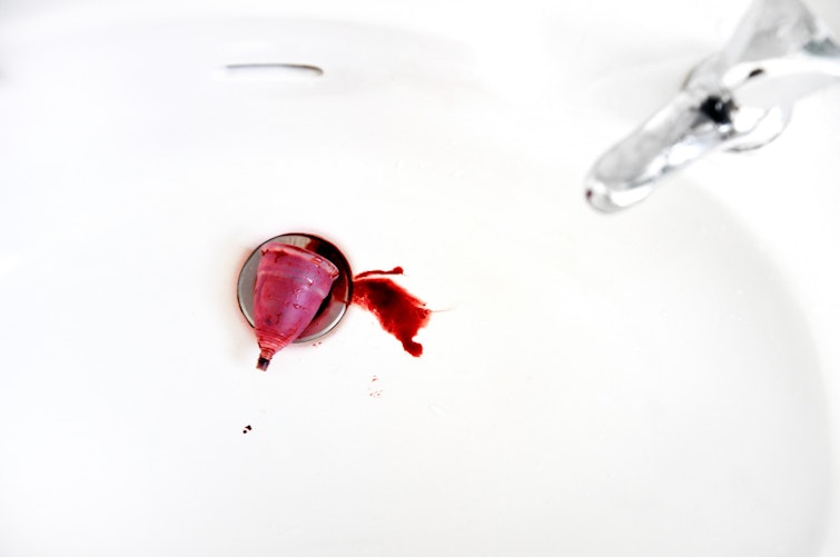 Menstrual cup in a white sink with blood
