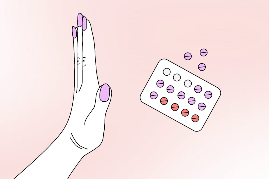 Hand pushing away packet of birth control pills