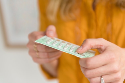 Woman's hands holding a pack of birth control pills