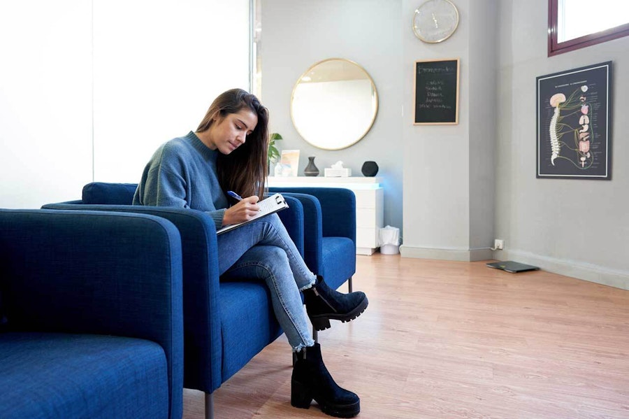 Woman filling in a form while waiting at the clinic