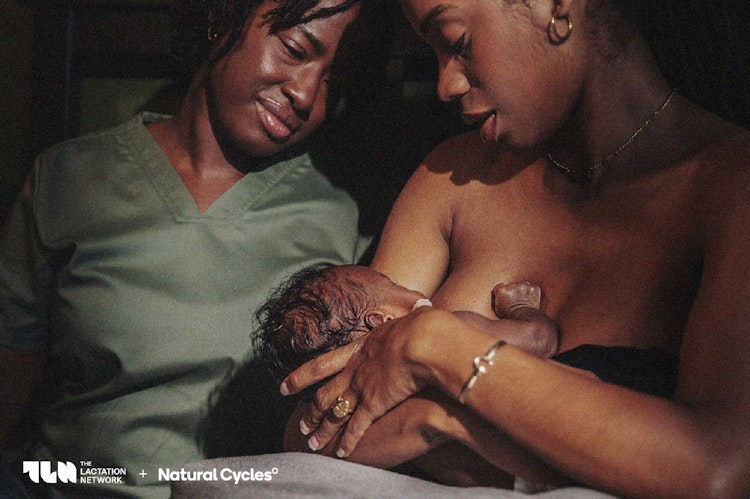 A mother nursing her baby with a lactation consultant watching on