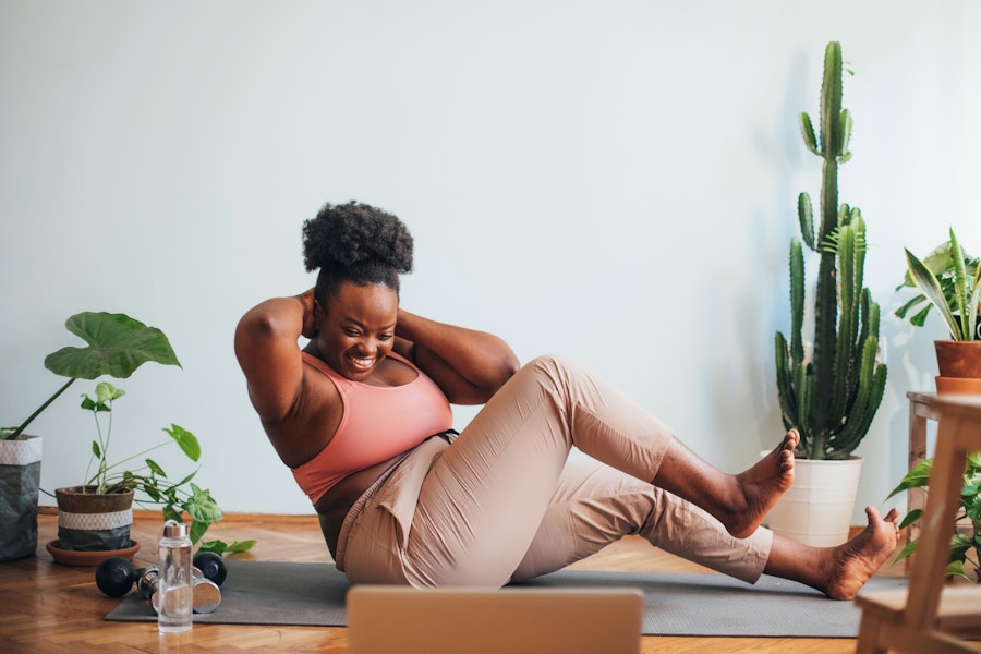 Woman doing crunches Smiling woman doing an ab workout