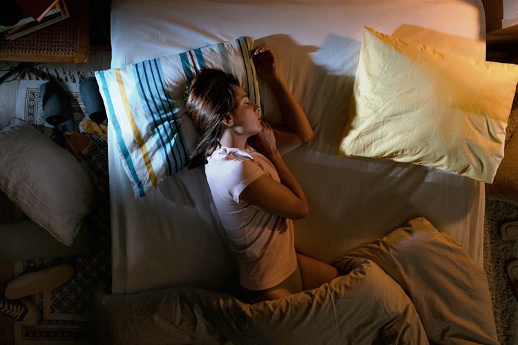 Woman sleeping on her side in bed
