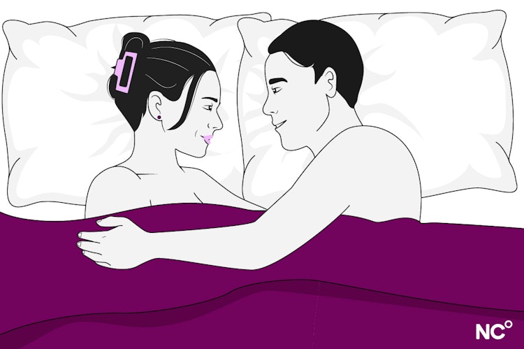 Illustration of a woman and man lying in bed under a purple cover facing eachother, embracing and smiling