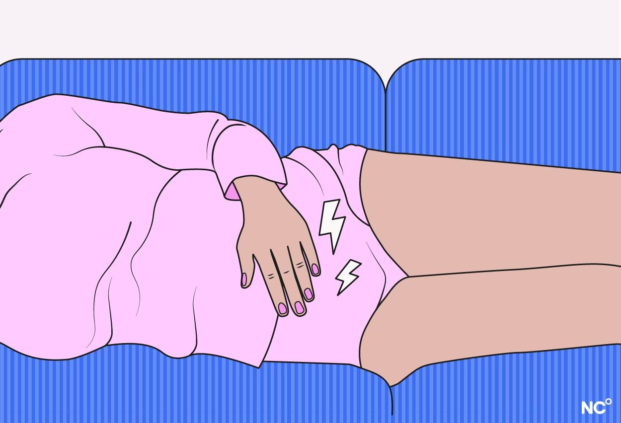 Illustration of a woman lying on her side on the couch with cramps