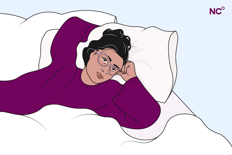 Illustration of a woman in a purple jumper lying in bed and looking tired