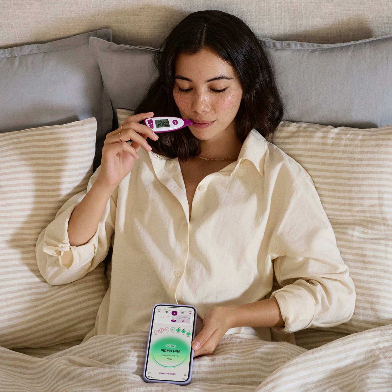 Thermometer with the app on the womans lap