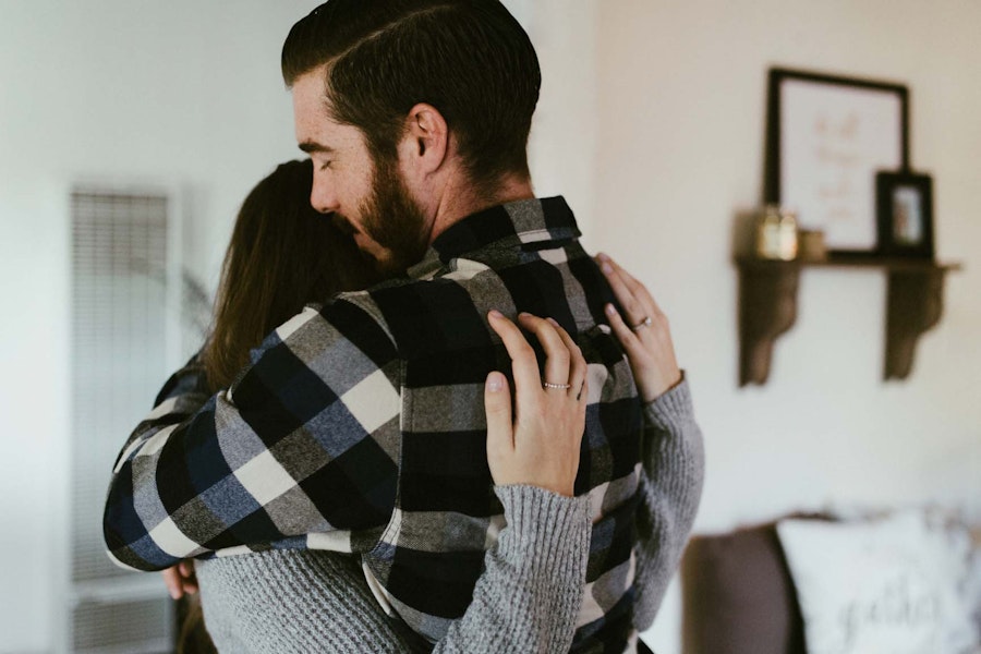 Photograph of young couple embracing in their living room