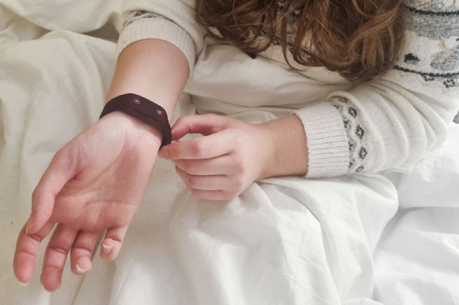 Photograph of Iona wearing the NC° Band in bed
