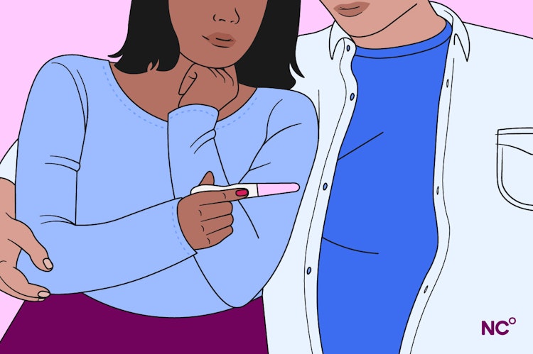 Couple cuddling and looking at a pregnancy test