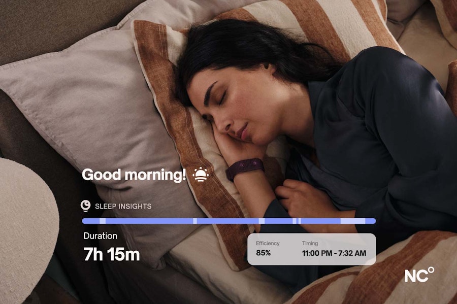 Woman lying in bed wearing the NC° Band there is an overlay of text showing her sleep data including that she slept for 7 hours and 15 mins