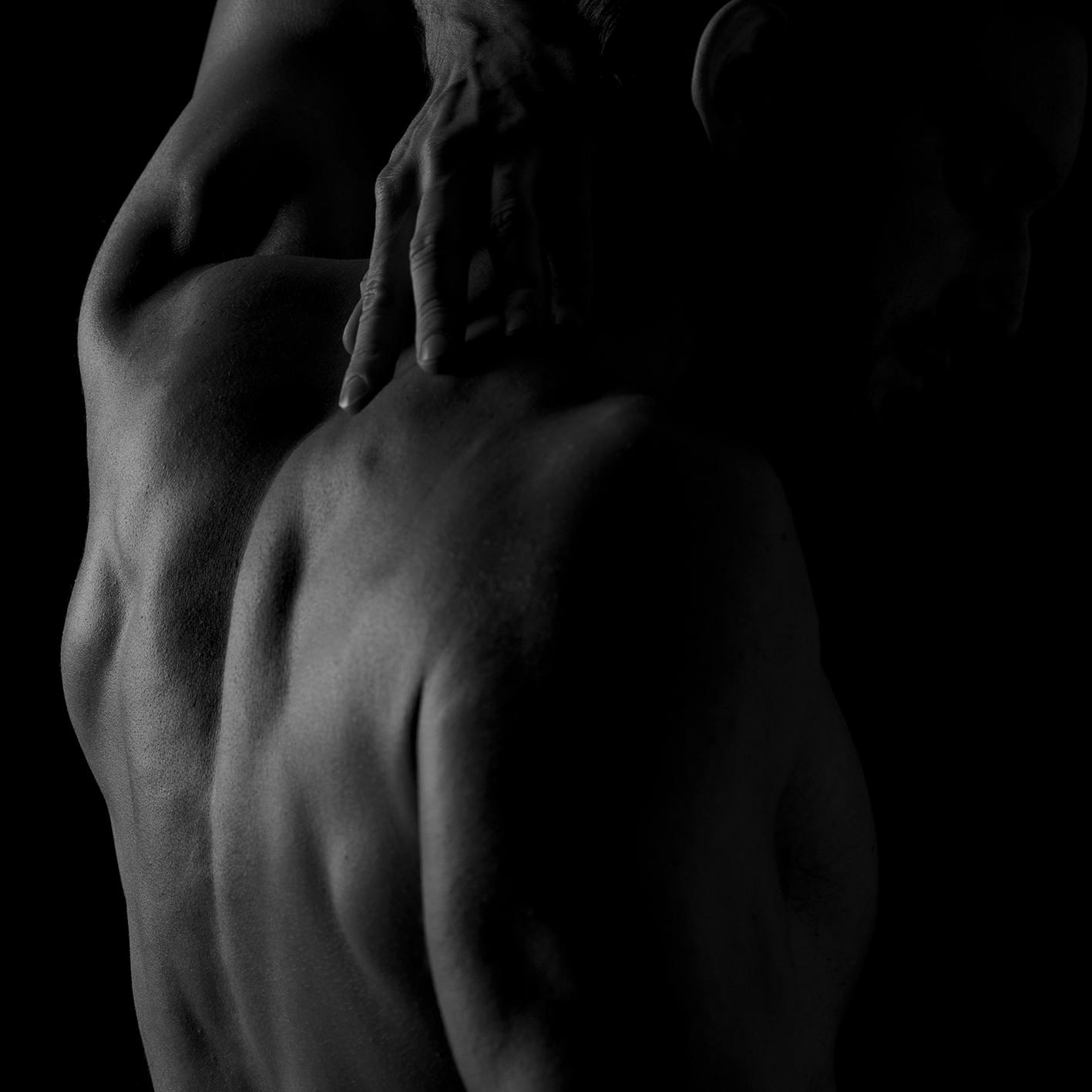 man touching the back of his neck
