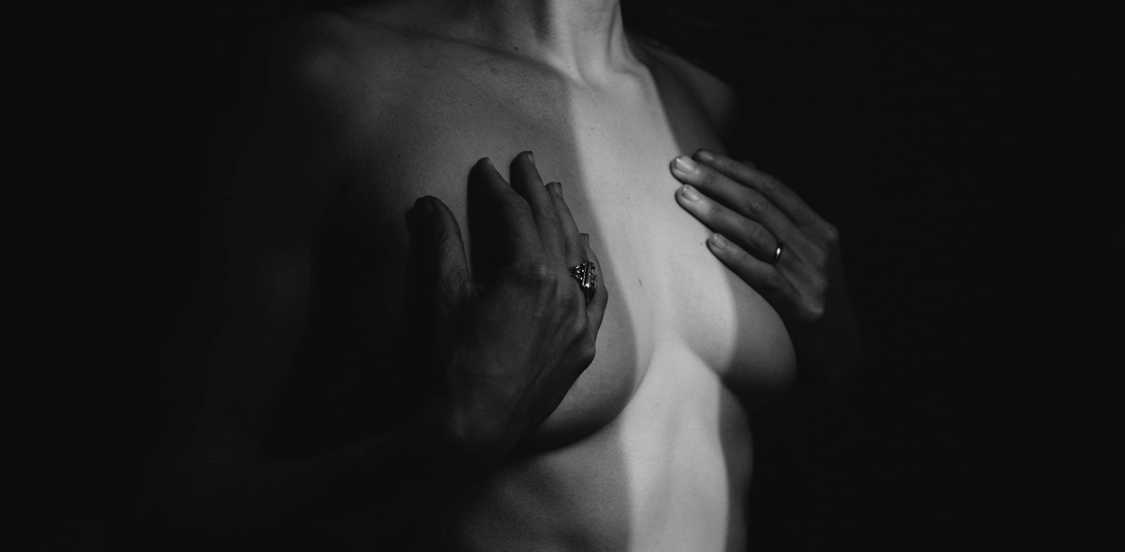 shirtless woman touching her chest