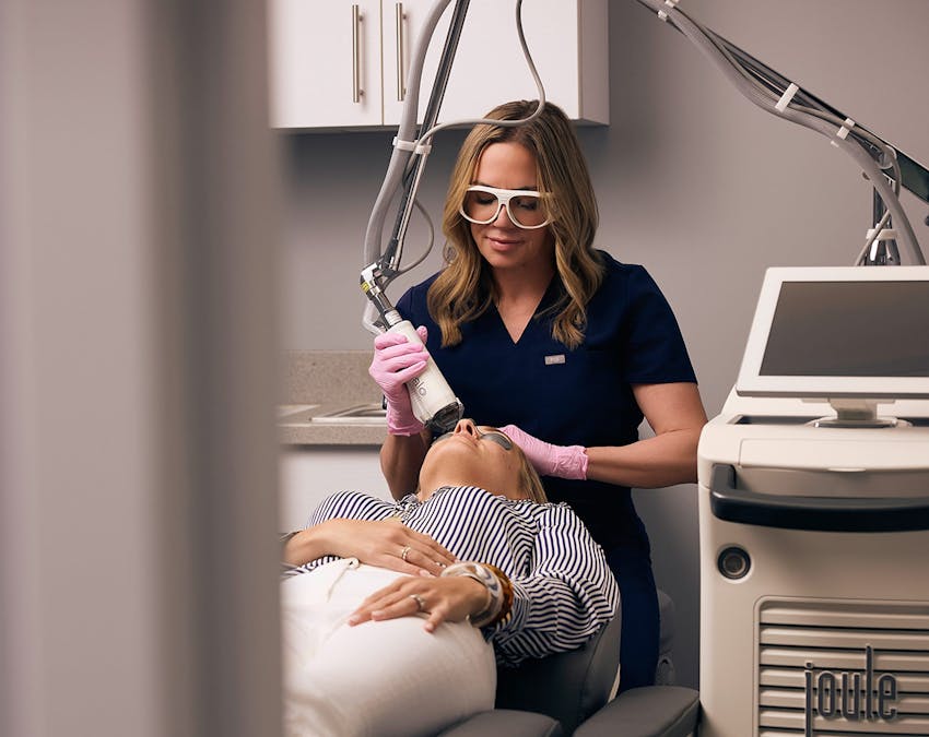 staff member using laser treatment on patient