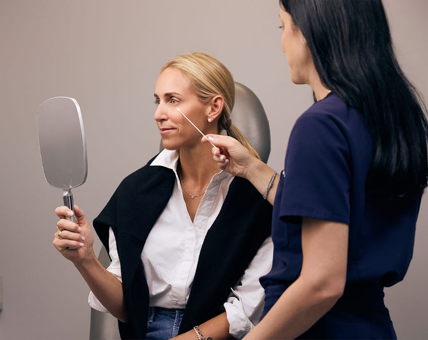 patient holding hand mirror