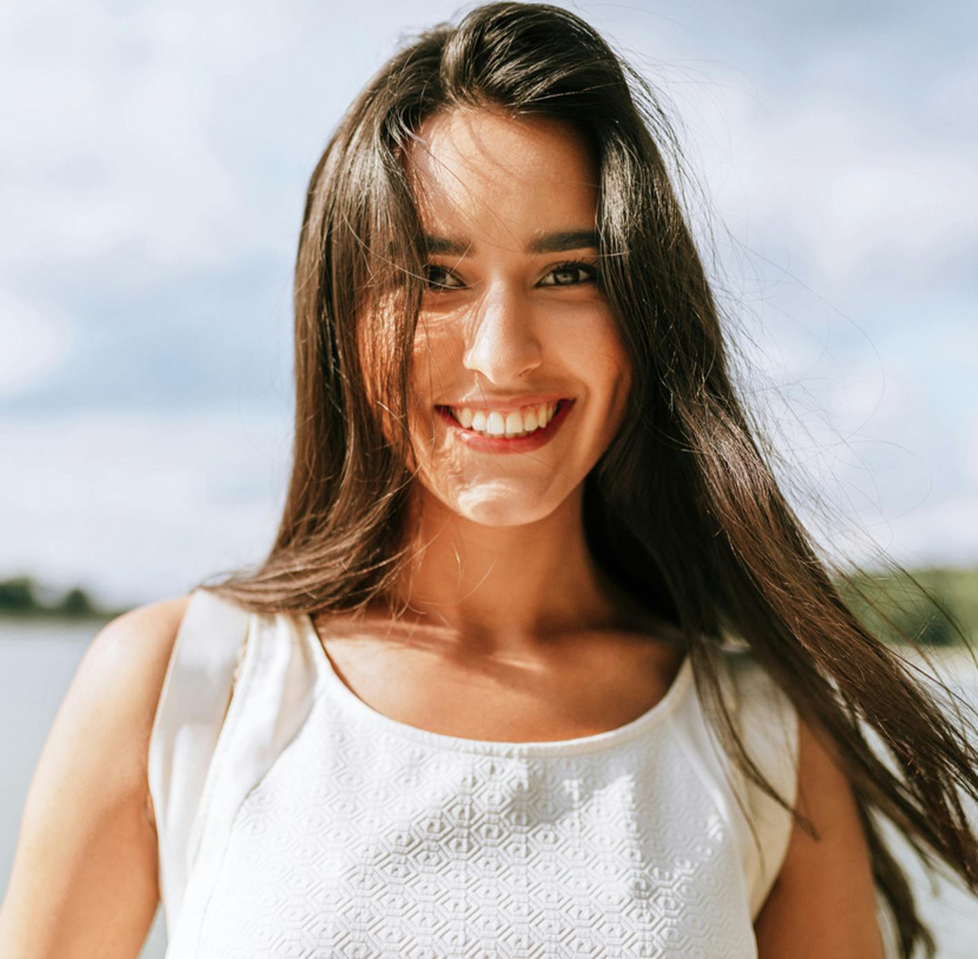smiling woman in front of water