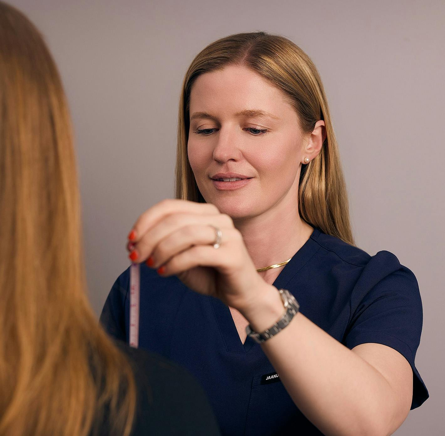 staff member taking patient's measurements
