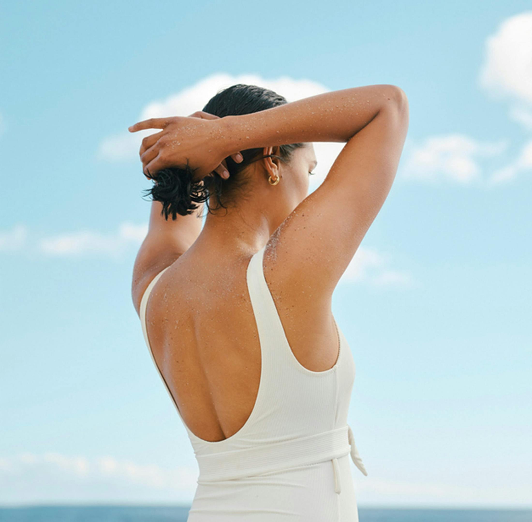 view of woman wearing a white top from behind