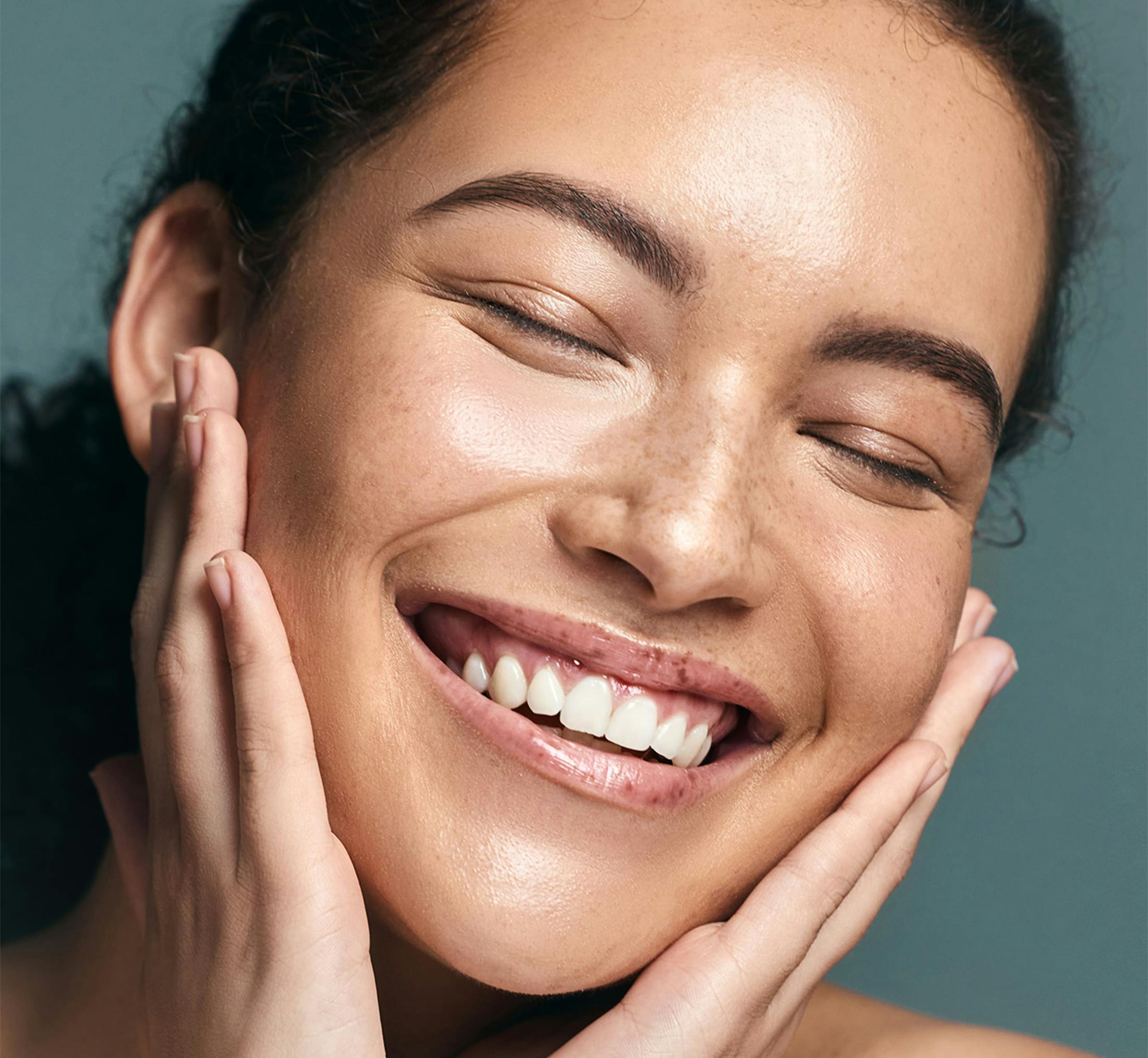 Woman smiling and touching her face