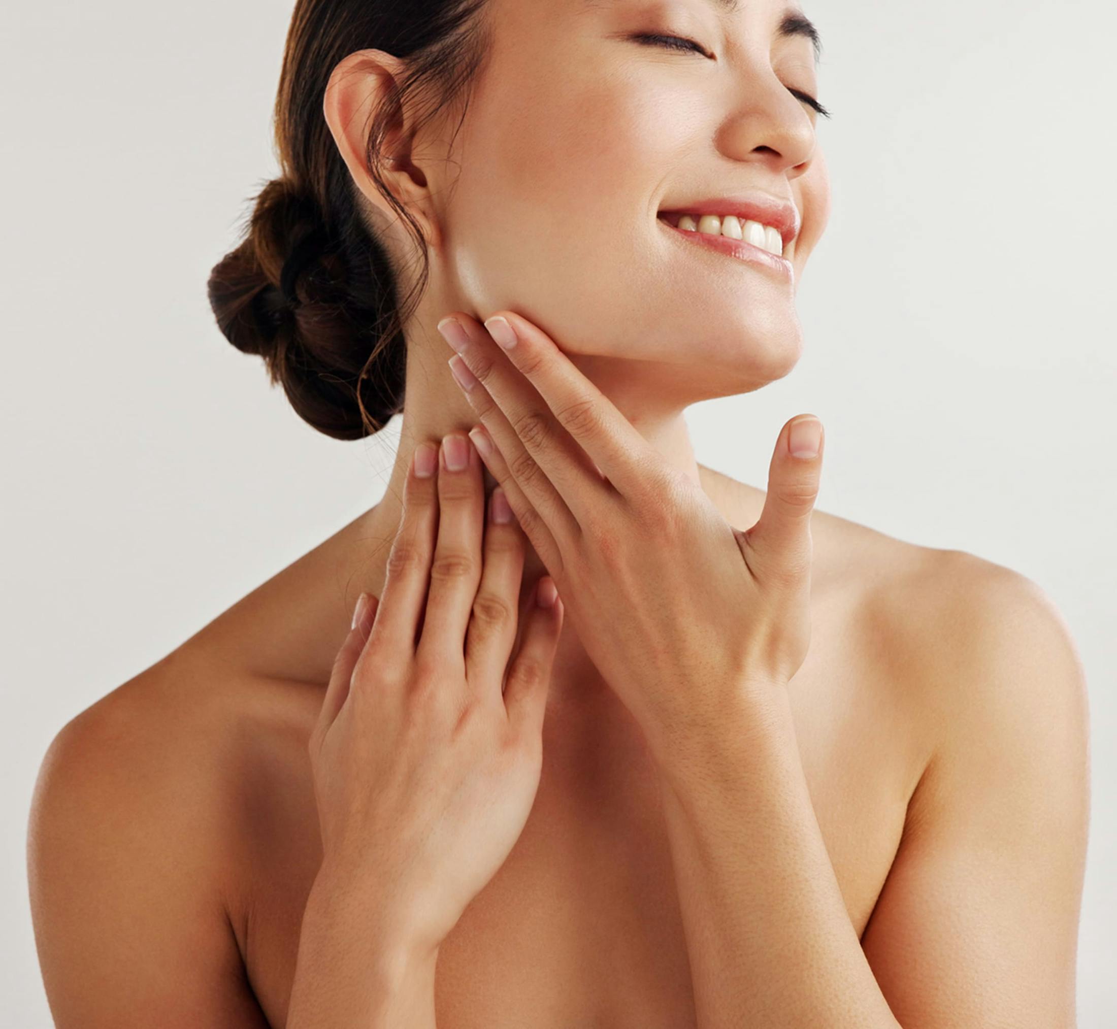 Woman smiling touching chin and neck